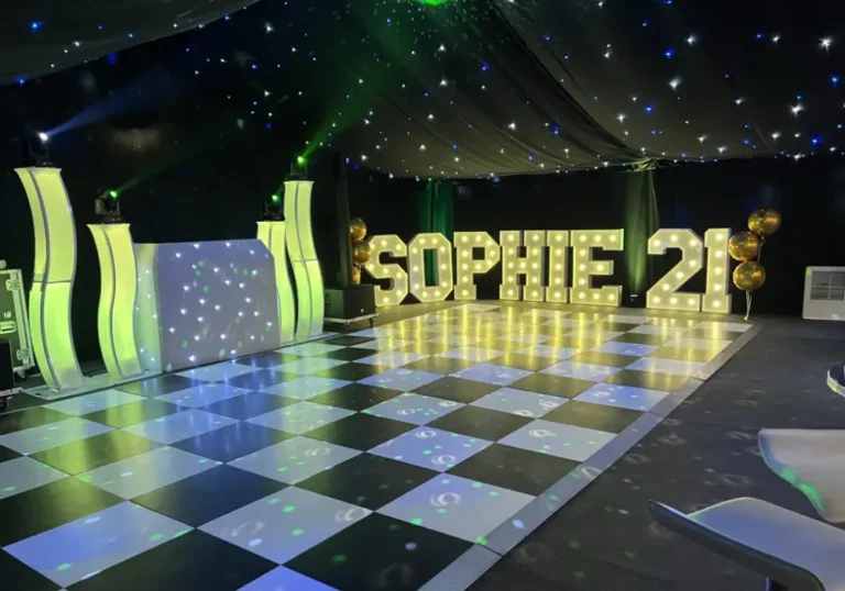 A party venue with a dance floor lit by colorful lights from Melody Corporation, large letters spelling "Sophie 21," and balloons, beneath a starry marquee.